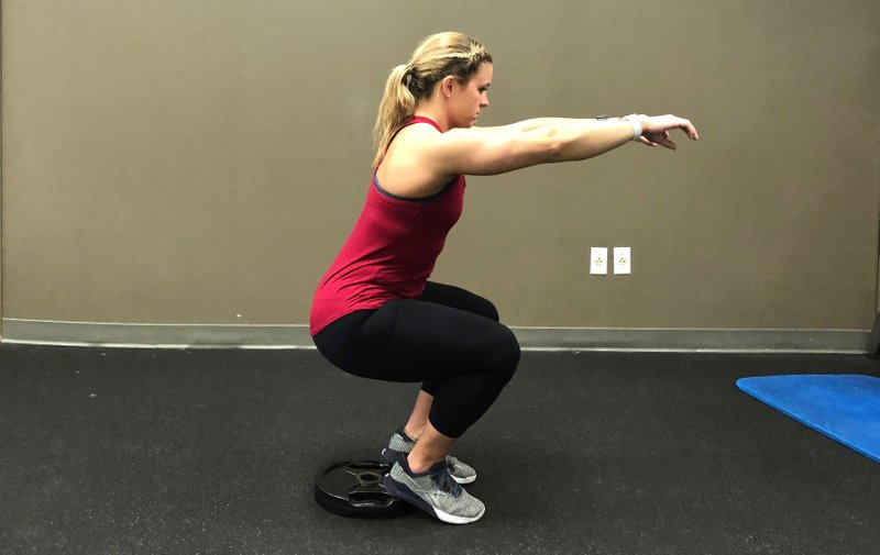 Katie Hough does the Heel Elevated Squat at Little Rock Racquet Club. (Arkansas Democrat-Gazette/Celia Storey)