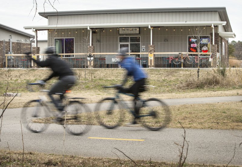 Cyclists ride past Nomads Trailside on Saturday on the Razorback Greenway in Fayetteville. Go to nwaonline.com/photos to see more photos. (NWA Democrat-Gazette/Ben Goff)