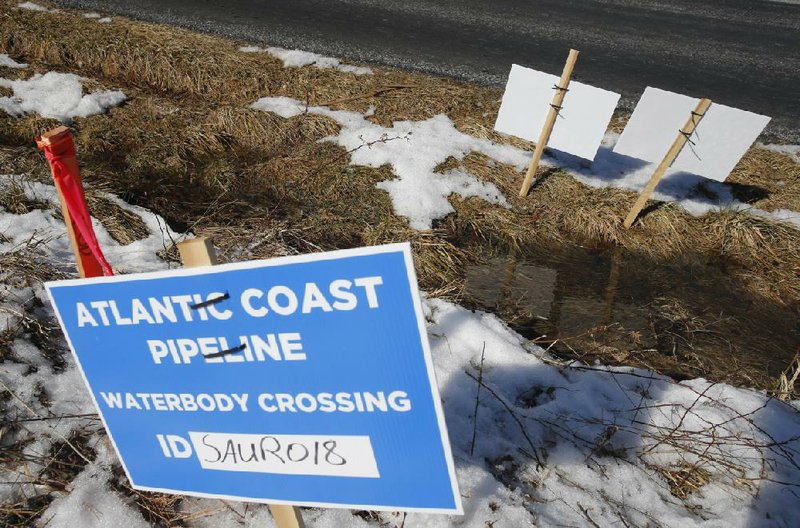 FILE - This Feb. 8, 2018, file photo shows signs that mark the route of the Atlantic Coast Pipeline in Deerfield, Va. The U.S. Supreme Court is set to wade into a long-running battle between developers of the 605-mile natural gas pipeline and environmental groups who oppose the pipeline crossing the storied Appalachian Trail. On Monday, Feb. 24, 2020, the high court will hear arguments on a critical permit needed by developers of the Atlantic Coast Pipeline. (AP Photo/Steve Helber)