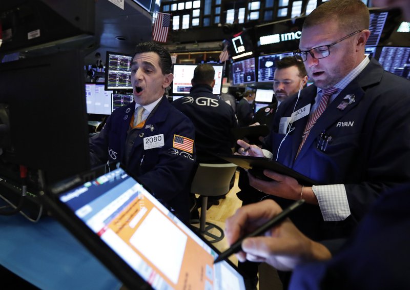 Specialist Peter Mazza (left) works with traders on the floor of the New York Stock Exchange on Monday as the spread of coronavirus cases shook the market. More photos at arkansasonline.com/225stock/.
(AP/Richard Drew)