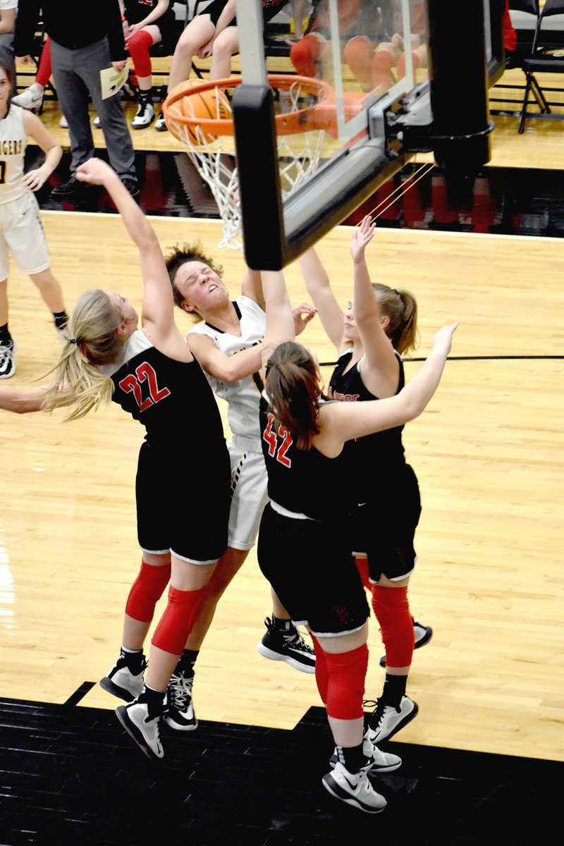 MARK HUMPHREY ENTERPRISE-LEADER Prairie Grove sophomore Trinity Dobbs draws a crowd and contact but no foul as three Pea Ridge defenders meet her after a drive to the hoop. Pea Ridge defeated the Lady Tigers, 48-26, in a Monday, Jan. 13, 2020, game rescheduled due to a severe weather threat the previous Friday.