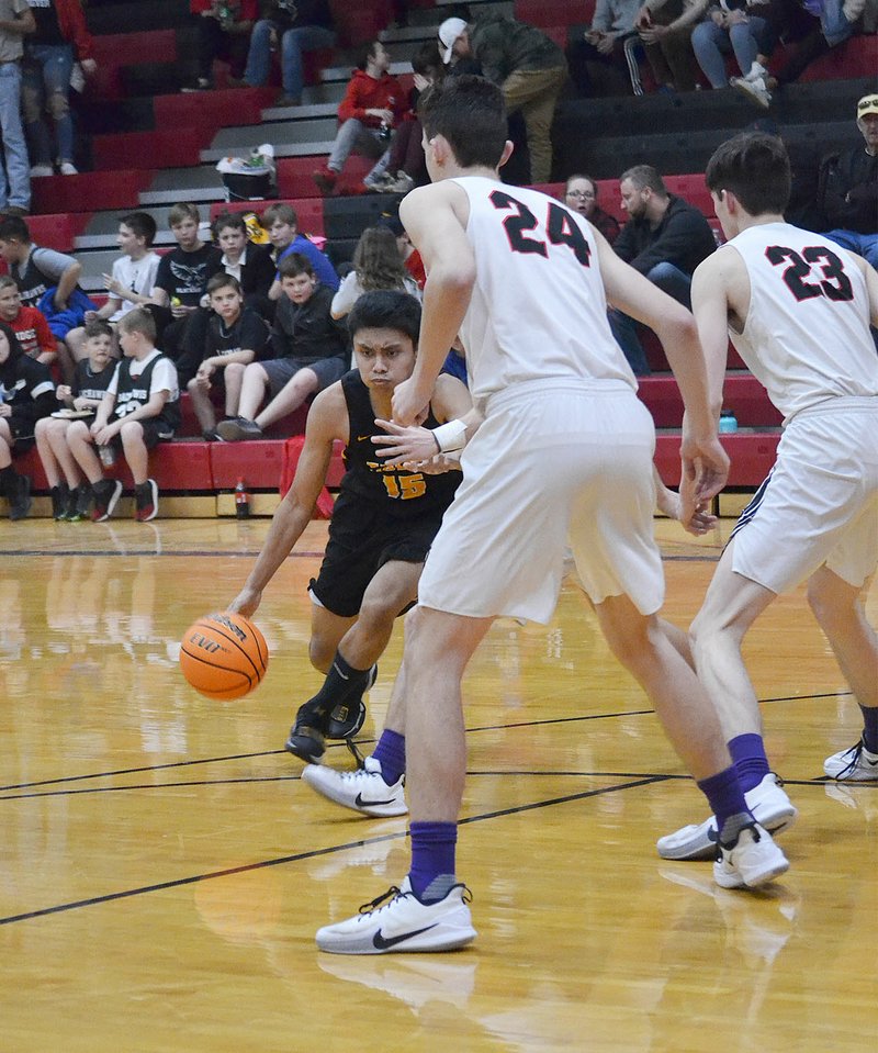TIMES photograph by Annette Beard Tiger Carl Von Bergen (No 15) drives down the court as Pea Ridge Blackhawk seniors Brandon Whatley (No. 24) and Wes Wales (No. 23) guard him Friday, Feb. 7, in Pea Ridge High School Blackhawk gym during the Colors Day game.