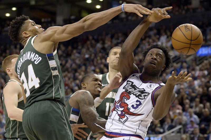 Toronto Raptors forward OG Anunoby (3) vies for a loose ball with Milwaukee Bucks forward Giannis Antetokounmpo (34) during the second half of Tuesday's game in Toronto. - Photo by Nathan Denette/The Canadian Press via The Associated Press