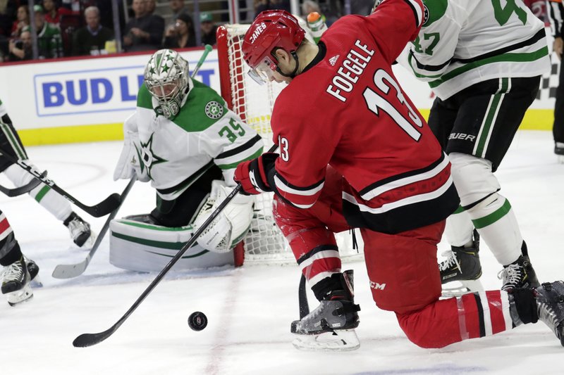 Dallas Stars' Anton Khudobin (35) defends the net against Carolina Hurricanes' Warren Foegele (13) during the third period of Tuesday's game against the Carolina Hurricanes in Raleigh, N.C. - Photo by Chris Seward of The Associated Press