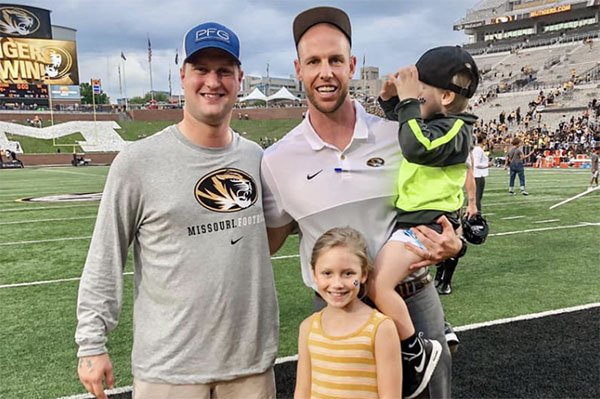 Travis Gipson (left) is shown with Joseph Henry and Henry's children Ford and Linley following a football game in Columbia, Mo.