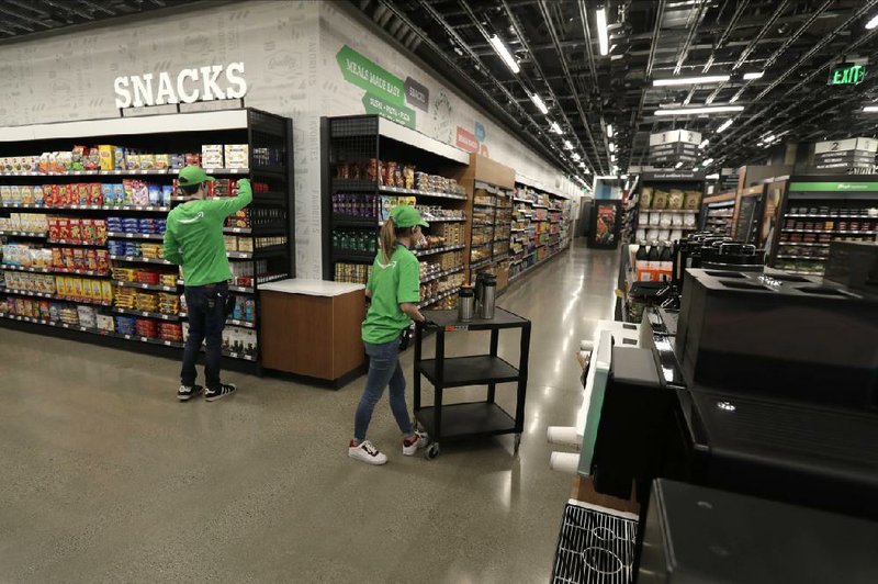 Workers stock shelves and a coffee station Friday inside an Amazon Go Grocery store ahead of its opening in Seattle’s Capitol Hill neighborhood.
(AP/Ted S. Warren)