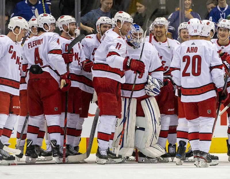 Members of the Carolina Hurricanes congratulate emergency goaltender David Ayres (center) following Saturday’s 6-3 victory over the Toronto Maple Leafs. Ayres, 42, became the oldest goaltender to win his NHL debut.
(AP/The Canadian Press/Frank Gunn)