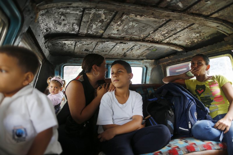 Passengers ride on public transport in Caracas, Venezuela, Wednesday, Feb. 19, 2020. Families have been split up with at least 4.5 million Venezuelans fleeing crumbling public services. (AP Photo/Ariana Cubillos)