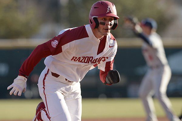 Arkansas first baseman Cole Austin heads to third base Friday, Feb. 21, 2020, on an RBI slash-bunt single by Robert Moore during the fifth inning at Baum-Walker Stadium in Fayetteville.