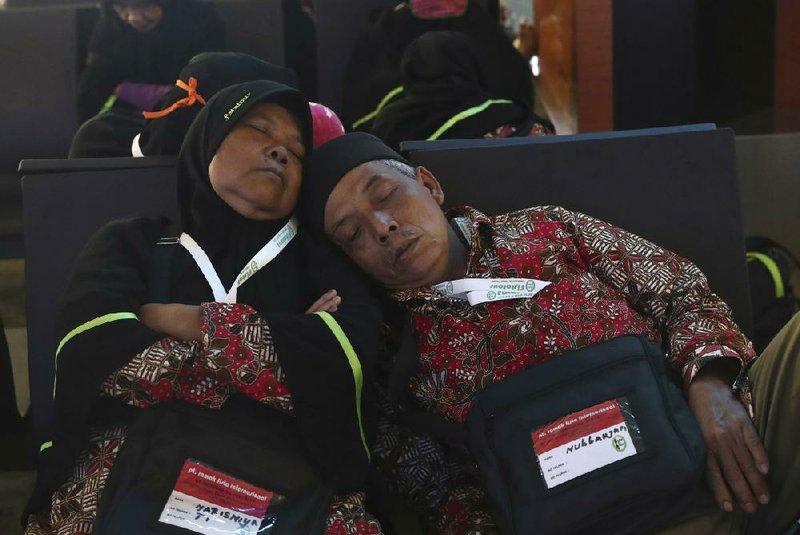 A couple dozes Thursday at the airport in Tangerang, Indonesia, after they were turned away from their flight to Saudi Arabia, where they had planned to take part in a minor pilgrimage called Umrah.
(AP/Tatan Syuflana)
