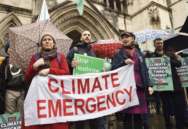 Campaigners protest outside the Royal Courts of Justice where a Court of Appeal ruling is taking place on the Heathrow expansion row, in London, Thursday, Feb. 27, 2020. Britain's Court of Appeal is preparing to publish its decision in a case that could stall the 14 billion pound ($18 billion) plan to expand Heathrow Airport amid concerns about climate change, pollution and noise. (Stefan Rousseau/PA via AP)