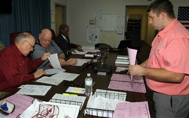 FILE - Administrator Sven Hipp, right, joins Jefferson County election officials, from left, Stuart Soffer, Michael Adam and Theodis Davis as they prepare documents for a special meeting concerning errors in early voting. (Arkansas Democrat-Gazette/Dale Ellis)