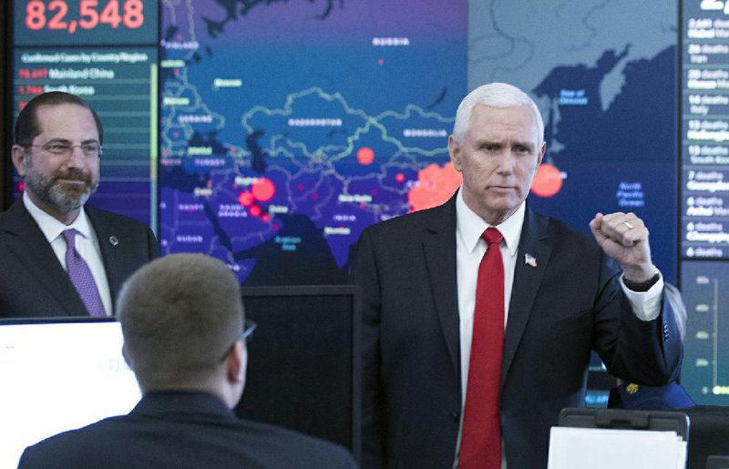 Vice President Mike Pence (center) and Health and Human Services Secretary Alex Azar (left) tour the coronavirus operations center Thursday in Washington after the first meeting of Pence’s task force. A large monitor behind them displays a count of virus cases, deaths and the number of patients who have recovered. More photos at arkansasonline.com/228virus/.
(AP/Andrew Harnik)