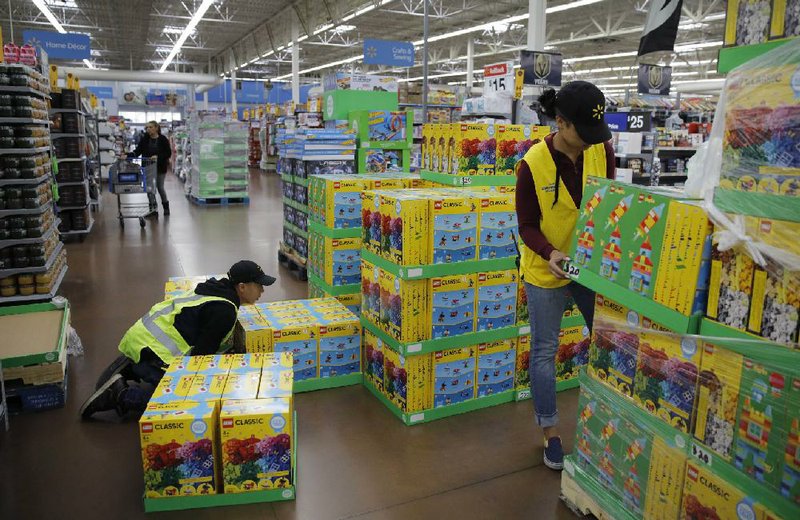 Walmart employees stock shelves in a Las Vegas supercenter in November. The retailer’s new fulfi llment service allows third-party vendors to use the Walmart delivery system and guarantees two-day delivery.
(AP/John Locher)