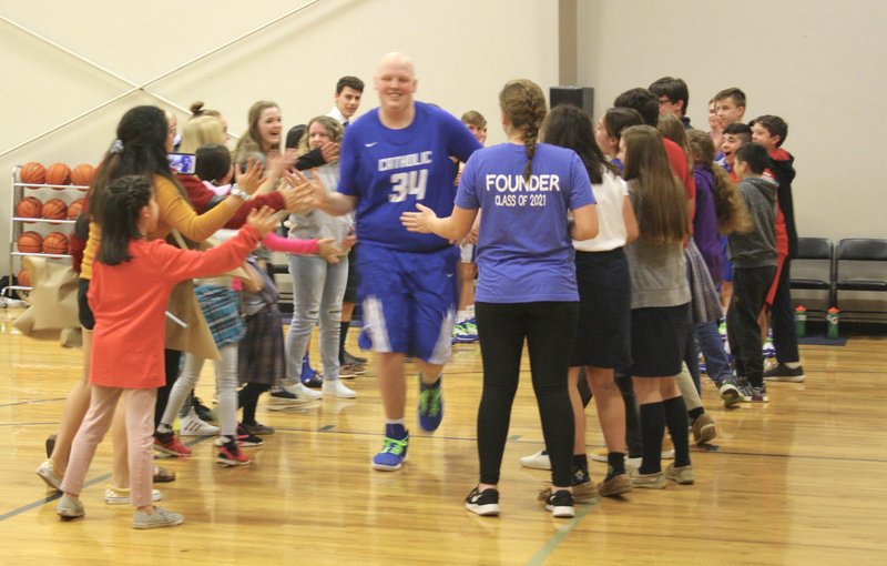 Matthew Moix is greeted by fans while taking the court for Ozark Catholic in its final basketball game of the season. It was the only appearance of the year for Moix, who is cancer free after being diagnosed with Non-Hodgkins Lymphoma on Aug. 23. (Photo submitted/Alesia Schaefer)