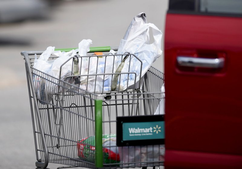 FILE — Groceries are transported in plastic bags in the parking lot of the Walmart Neighborhood Market on Martin Luther King Jr. Drive in Fayetteville in this March 1, 2020 file photo. (NWA Democrat-Gazette/David Gottschalk)