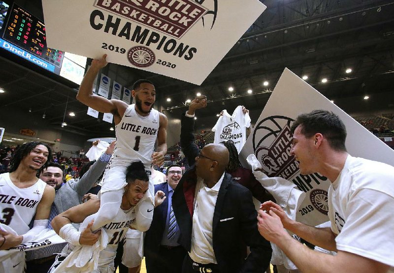 UALR Coach Darrell Walker celebrates with his players after the Trojans clinched the Sun Belt Conference regular-season championship with a victory over Louisiana-Lafayette on Saturday at the Jack Stephens Center in Little Rock. More photos available at arkansasonline.com/31ualrbball.
(Arkansas Democrat-Gazette/Thomas Metthe)