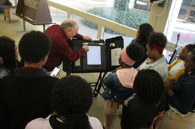 Surrounded by students from Pine Bluff High School, Jefferson County Election Commissioner Stu Soffer, center, demonstrates the functions of the iVotronics touch-screen voting machines that voters will be using in the March 3 primary election. Seventeen students from Pine Bluff High School and nine students from White Hall High School went through training Monday and Tuesday to work the polls as election pages. (Arkansas Democrat-Gazette/Dale Ellis)