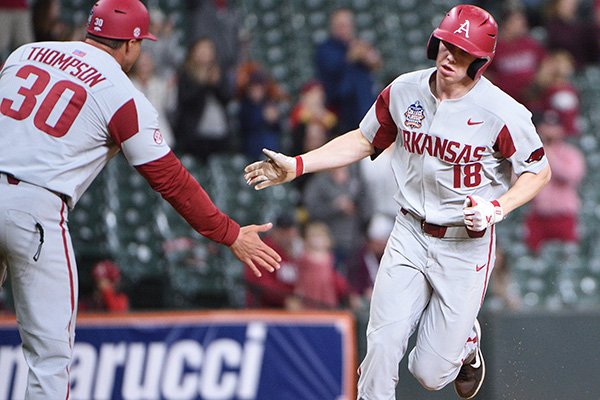 Arkansas outfielder Heston Kjerstad (18) is congratulated by hitting coach Nate Thompson after hitting a home run during a game against Texas on Saturday, Feb. 29, 2020, during the Shriners Hospitals for Children College Classic at Minute Maid Park in Houston. 