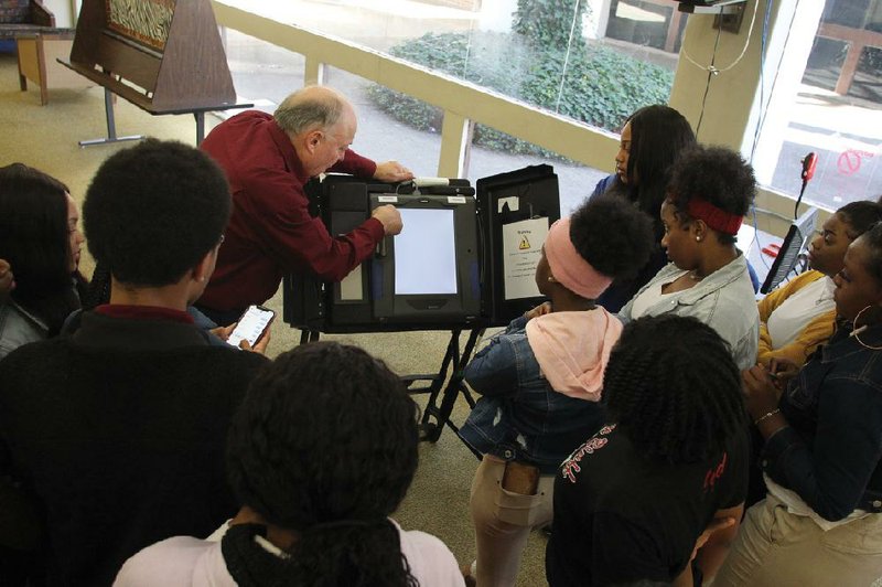 File-Surrounded by students from Pine Bluff High School, Jefferson County Election Commissioner Stu Soffer, center, demonstrates the functions of the iVotronics touch-screen voting machines that voters used in the March 3 primary election. Seventeen students from Pine Bluff High School and nine students from White Hall High School went through training to work the polls as election pages.
 (Arkansas Democrat-Gazette/Dale Ellis)