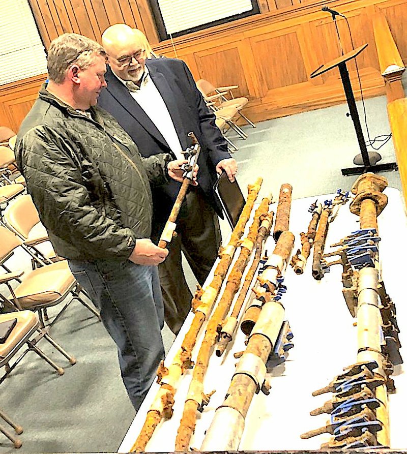 Robert Edmonds, director of public works, left, shows El Dorado City Council Member Paul Choate the poor condition of water lines that have been replaced in the city’s water and wastewater infrastructure. The pipes were on display during a recent El Dorado City Council meeting. Today, the council is expected the hear the third reading of an ordinance that would raise water and wastewater rates to a level that will help pick up the pace in making much-needed infrastructure repairs, per a recommendation in a comprehensive cost-analysis and strategic planning study that was compiled for the El Dorado Water Utilities.