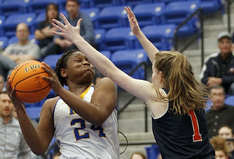 North Little Rock’s Destine Duckworth (24) attempts a shot while defended by Rogers Heritage’s Pam Seiler on Wednesday during the first quarter of North Little Rock’s 66-21 victory in the Class 6A girls state basketball tournament at Bryant. See more photos at arkansasonline.com/35girls6a/
(Arkansas Democrat-Gazette/Thomas Metthe)