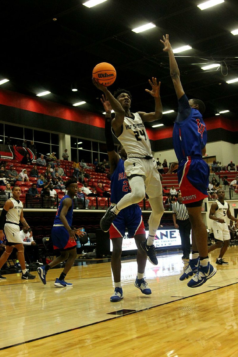 Caleb Campbell of Hot Springs shoots around a Little Rock Parkview defender in the Trojans’ 75-65 victory in the first round of the Class 5A boys state tournament in Russellville. Campbell scored 21 points in the victory.
(The Sentinel-Record/James Leigh)