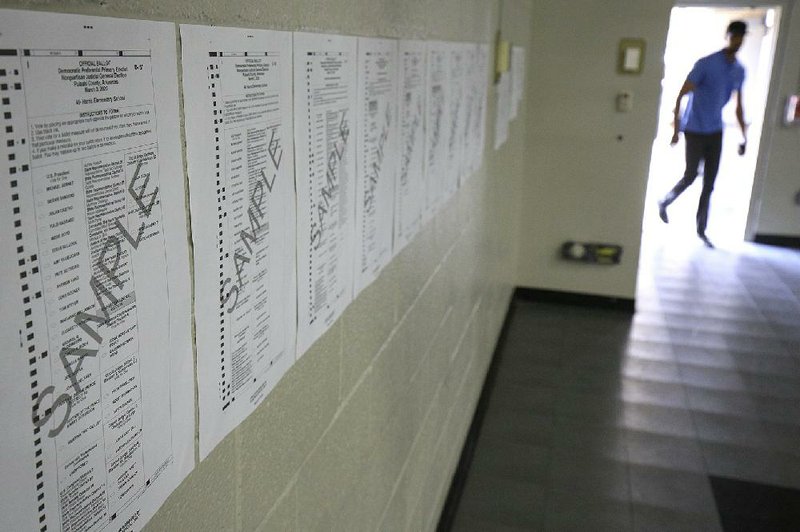 In this file photo sample ballots line the wall Tuesday March 3, 2020 at Harris Elementary School in North Little Rock. 
(Arkansas Democrat-Gazette/Staton Breidenthal)  


