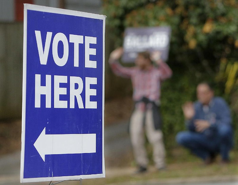 Supporters of a candidate cavort across the street from a polling place in Little Rock's Hillcrest neighborhood Tuesday afternoon, March 3, 2020.  (Arkansas Democrat-Gazette/John Sykes Jr.)