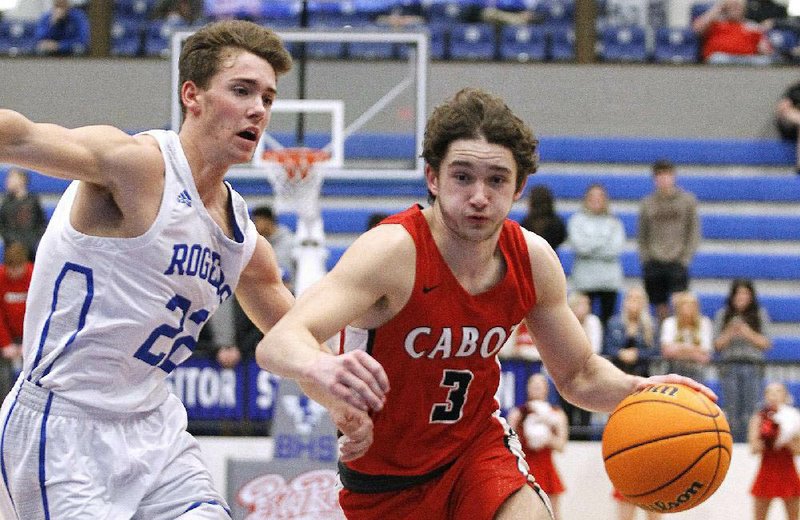 Cabot’s Jackson Muse (right) dribbles toward the basket past Derek Hobbs of Rogers during Cabot’s victory Wednesday in the first round of the Class 6A boys state tournament in Bryant. More photos available at arkansasonline.com/35boys6a.
(Arkansas Democrat-Gazette/Thomas Metthe)