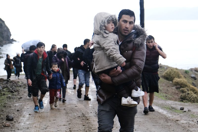 Migrants walk to the village of Skala Sikaminias, on the Greek island of Lesbos, after crossing on a dinghy the Aegean sea from Turkey on Thursday, March 5, 2020. Turkey said Thursday it would deploy special forces along its land border with Greece to prevent Greek authorities from pushing back migrants trying to cross into Europe, after Turkey declared its previously guarded gateways to Europe open. (AP Photo/Alexandros Michailidis)