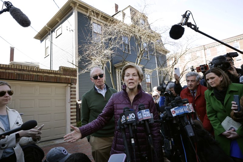 Sen. Elizabeth Warren, D-Mass., with her husband Bruce Mann beside her, speaks to the media outside her home, Thursday, March 5, 2020, in Cambridge, Mass., after she dropped out of the Democratic presidential race. (AP Photo/Steven Senne)