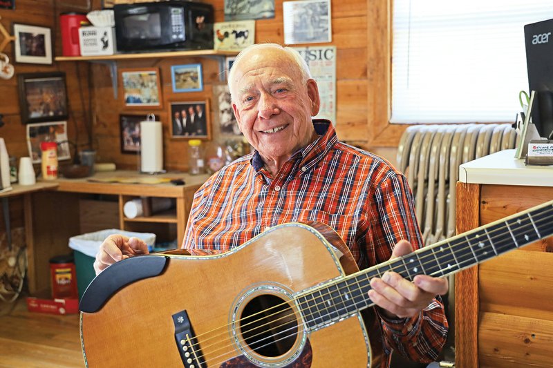 Andy Rutledge dusts off the guitar in his Ozark RV Park office that doubles as a jam-session space. Rutledge is one driving force behind the Mountain View Bluegrass Festival, scheduled for Thursday through Saturday.