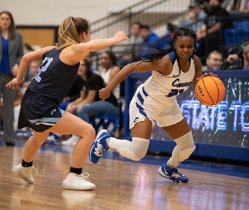 Conway guard T’yauna Rector (right) drives past Springdale Har-Ber’s Maddux McCrackin during the second quarter of the teams’ 6A state tournament game at Bryant. Conway won 73-56.
(Arkansas Democrat-Gazette/Justin Cunningham)