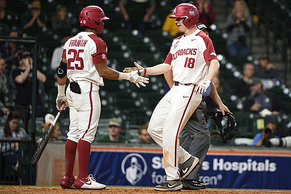 Arkansas center fielder Christian Franklin (25) congratulates right fielder Heston Kjerstad as he scores during the eighth inning of a game against Baylor on Sunday, March 1, 2020, during the Shriners Hospitals for Children College Classic at Minute Maid Park in Houston. 