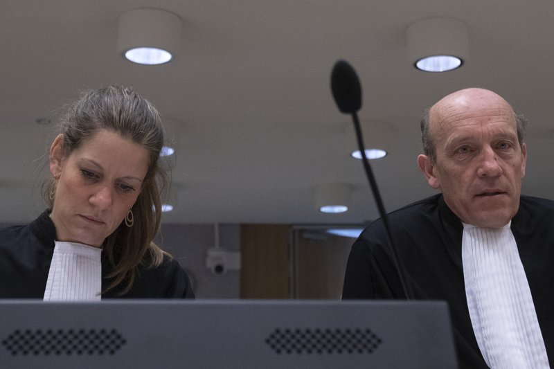 Lawyers for one of the four accused Sabine ten Doesschate, left, and Boudewijn van Eijck, right, are seen in court on the second day of the trial of four men charged with murder over the downing of Malaysia Airlines flight 17, at Schiphol airport, near Amsterdam, Netherlands, Tuesday, March 10, 2020. A missile fired from territory controlled by pro-Russian rebels in Ukraine in 2014, tore the MH17 passenger jet apart killing all 298 people on board. (AP Photo/Peter Dejong)