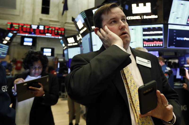 Brian Connolly, with NYSE Trading Floor Operations, works on the floor of the New York Stock Exchange during the trading halt, Thursday, March 12, 2020. (AP Photo/Richard Drew)