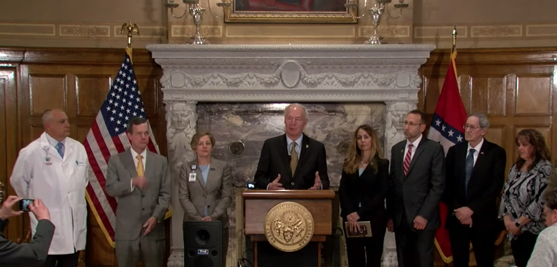 Gov. Asa Hutchinson, center, gives an update on coronavirus in Arkansas on Thursday.