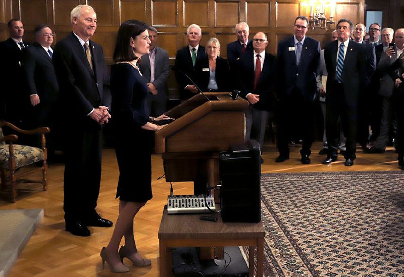 Gov. Asa Hutchinson (left) announced Thursday at the state Capitol that Little Rock business consultant Marie Holder (at lectern) was named to the Arkansas Highway Commission. As a commissioner, “I will put safety first in every decision I make,” Holder declared.
(Arkansas Democrat-Gazette/John Sykes Jr.)