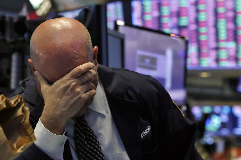 A trader spends another tough day Thursday on the floor of the New York Stock Exchange. More photos at arkansasonline.com/313stocks/.
(AP/Richard Drew)