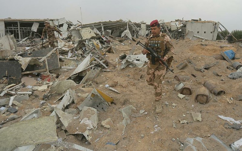 Iraqi soldiers on Friday inspect the destruction left at an airport complex in Karbala after U.S. jets fired missiles Thursday on several weapons depots in Iraq in retaliation for the deaths earlier this week of American and British servicemen at a base north of Baghdad.
(AP/Anmar Khalil)