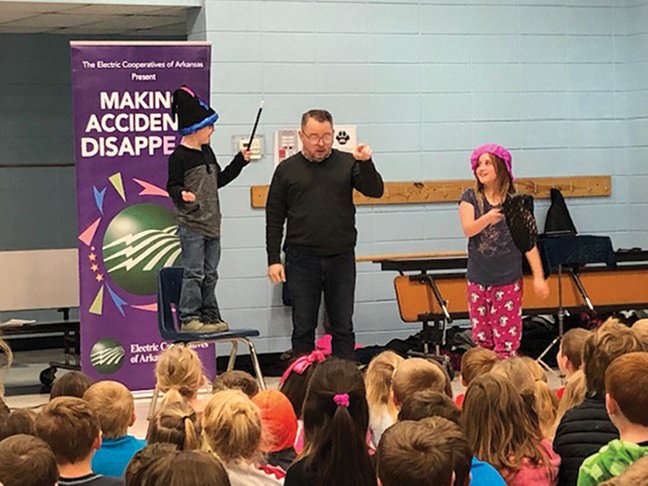 Magician Scott Davis presented a program on electrical safety at Magnet Cove Elementary School. From left are Alex Scott, kindergartner, Davis and fourth-grader Haidyn Valdes. - Submitted photo