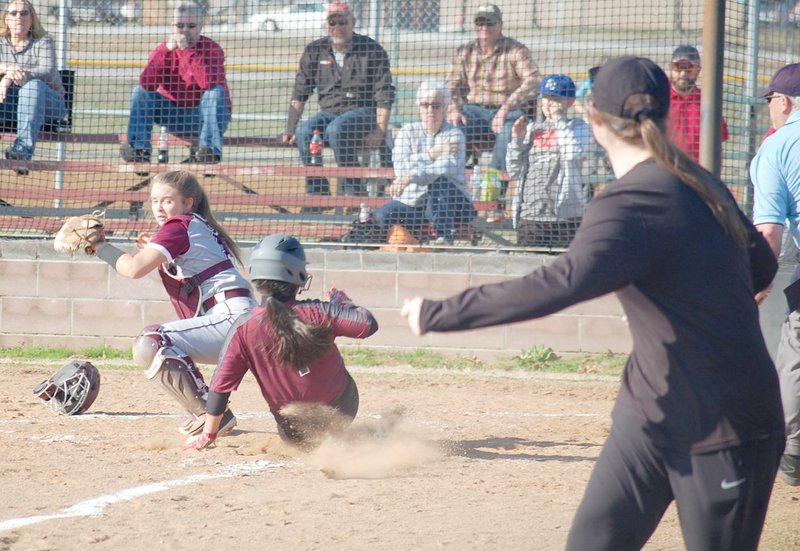 Graham Thomas/Siloam Sunday Siloam Springs head softball coach Emily Grace Ruggeri looks on as Lady Panthers runner Erica Cedillo slides safely into home ahead of Huntsville catcher April Hawpe's tag during Tuesday's game at La-Z-Boy Park.