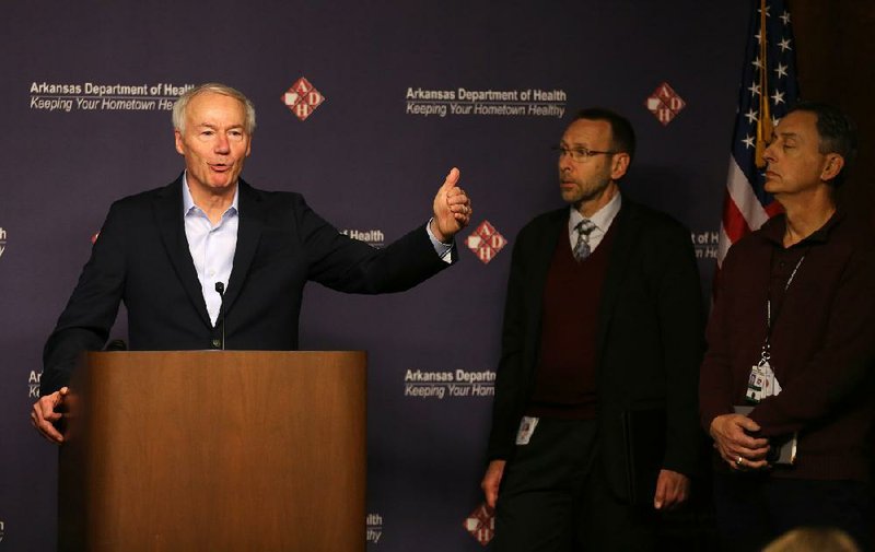 Gov. Asa Hutchinson announces three new coronavirus cases Saturday at a news conference at the Health Department. Hutchinson said he has activated the state emergency operations center and the Arkansas National Guard to help with logistics and transportation and to help the Health Department answer calls from health care providers and the public. With the governor are Dr. Nate Smith (middle), state secretary of health, and A.J. Gary, state homeland security adviser.
(Arkansas Democrat-Gazette/Thomas Metthe)