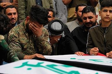 Mourners and Iraqi militia fighters weep Saturday in Najaf at the flag-draped coffins of two fighters of the Popular Mobilization Forces, a coalition of militias including some backed by Iran. The two were killed in a U.S. airstrike.
(AP/Anmar Khalil)