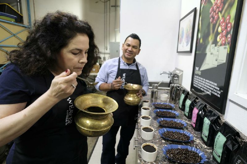 In this photo taken last week, Renee Brown, vice-president of Wild Card Roasters, samples different coffees as assistant roaster Carlos Garcia looks on at her roastery and cafe in San Rafael, Calif. (AP/Eric Risberg) 
