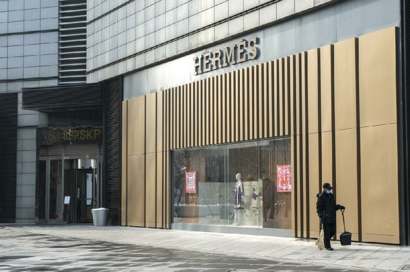 A cleaner walks past a Hermes International SCA store in Beijing. story.lead_photo.caption