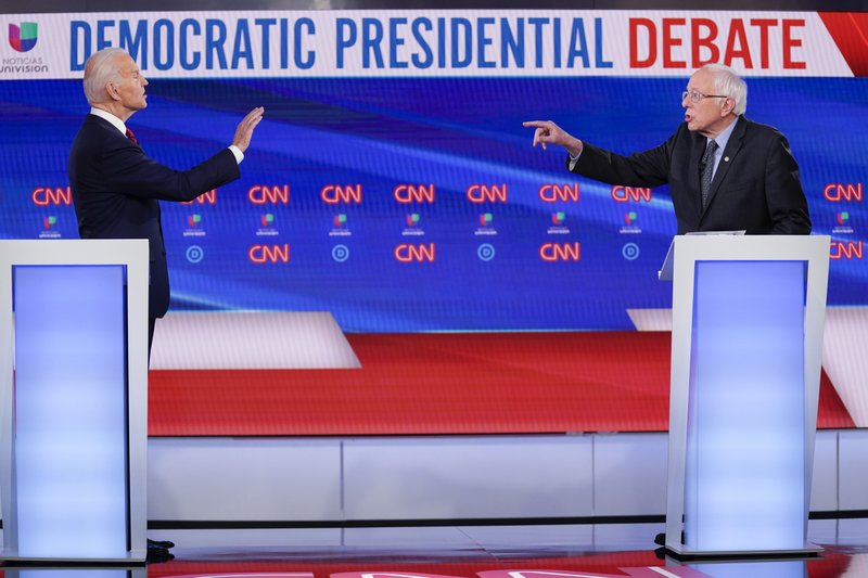 Former Vice President Joe Biden (left) and Sen. Bernie Sanders have an exchange Sunday while participating in a Democratic presidential primary debate in Washington. (AP/Evan Vucci) 
