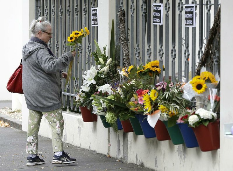 A woman leaves flowers Sunday outside the Al Noor Mosque in Christchurch, New Zealand. (AP/Mark Baker) 