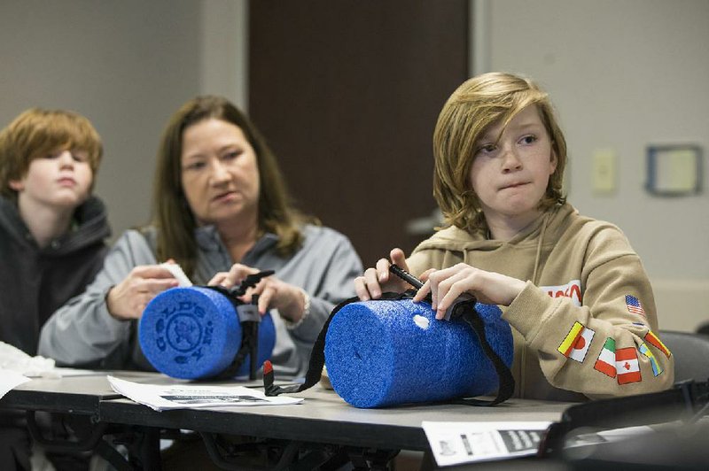 Dylan Rogers (right), 11, of Rogers learns how to use a tourniquet last month during a Stop the Bleed class at Northwest Medical Center in Bentonville. The free class taught participants how to stop bleeding and save lives after a traumatic injury. (NWA Democrat-Gazette/Ben Goff) 
